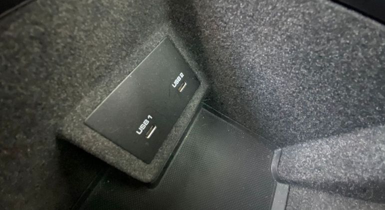 Dentro do console há um porta objetos e dois pontos de USB-C