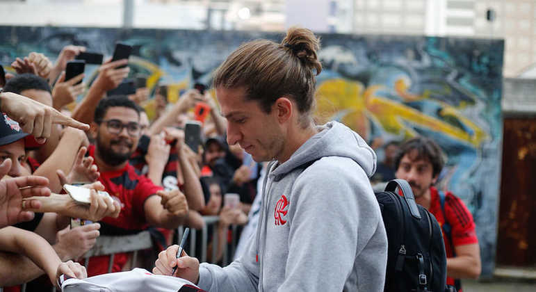 Outros jogadores também atenderam a torcida na chegada ao hotel. Filipe Luís deu autógrafos aos fãs.