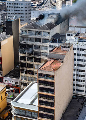 Bombeiros combatem incêndio em prédio próximo à rua 25 de março